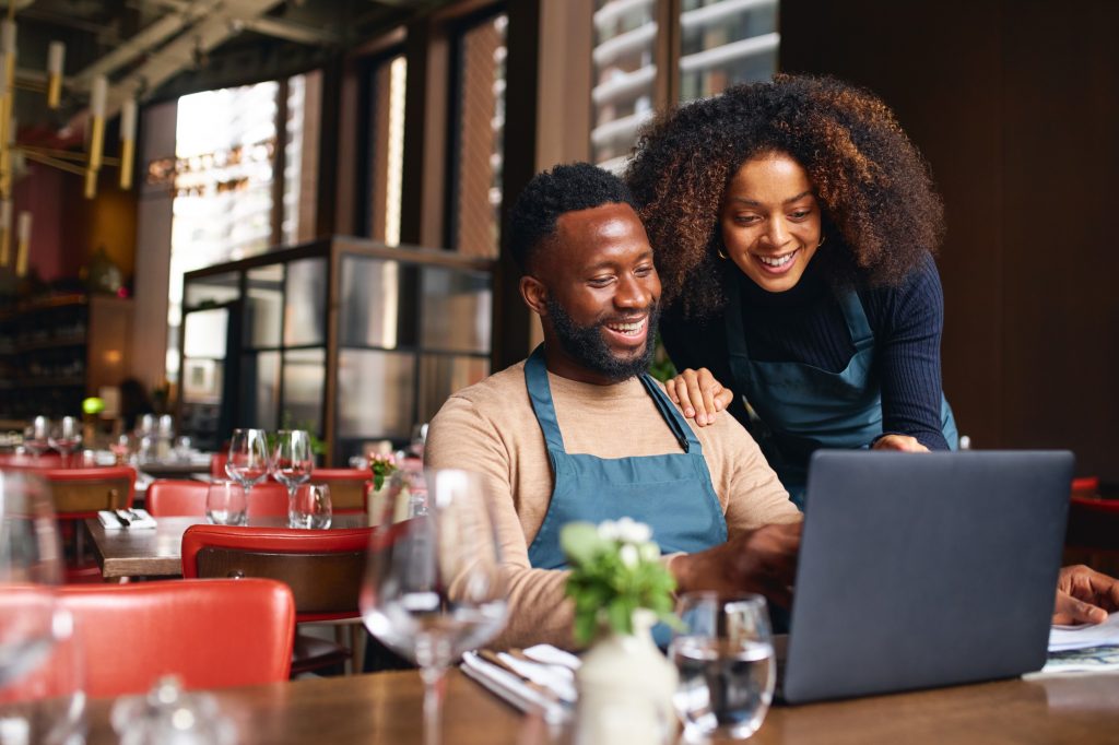 Hospitality workers working together at a laptop